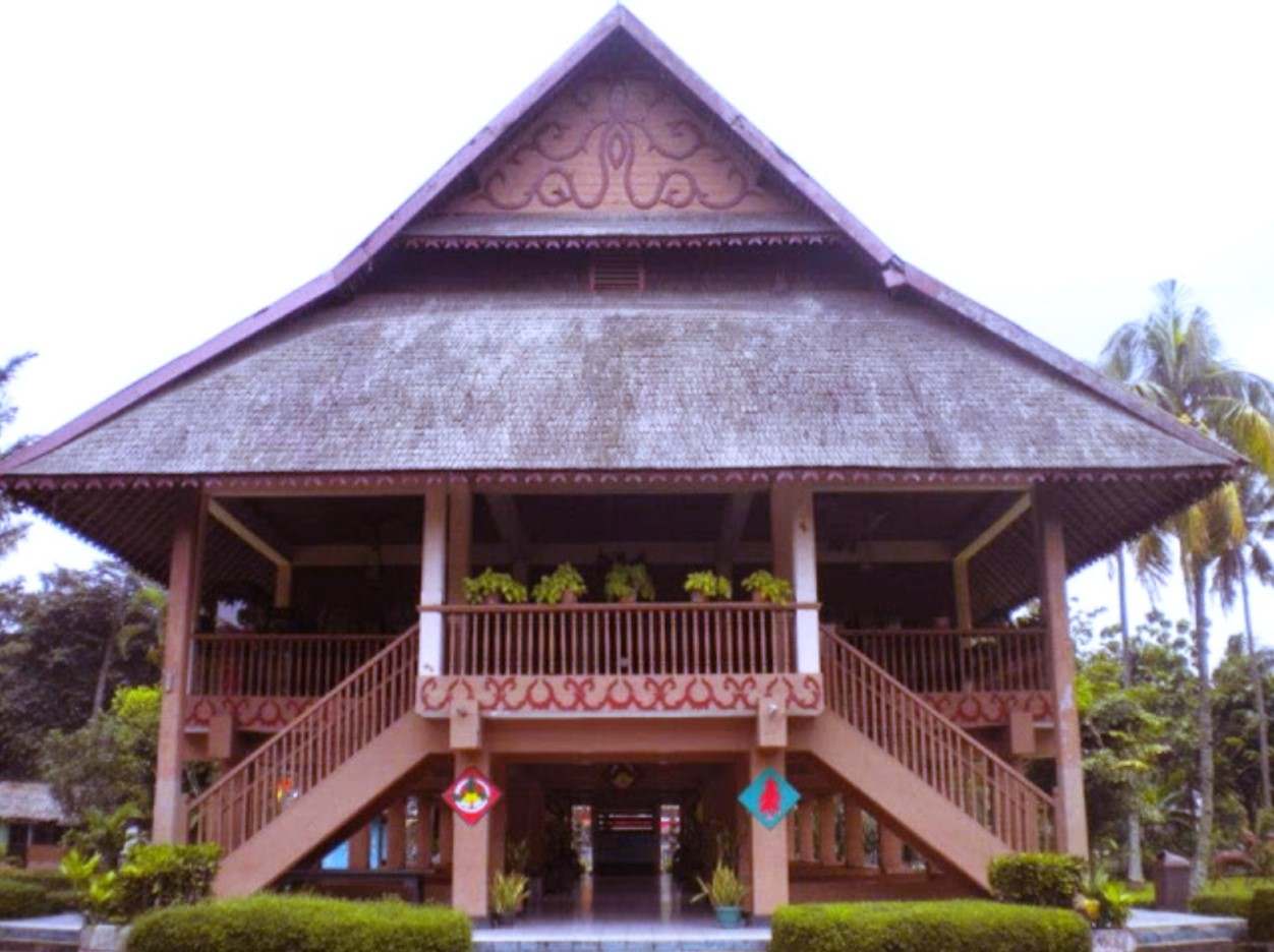 Rumah adat tradisional Bolaang Mongondow dengan teras dan tangga di bagian depan.